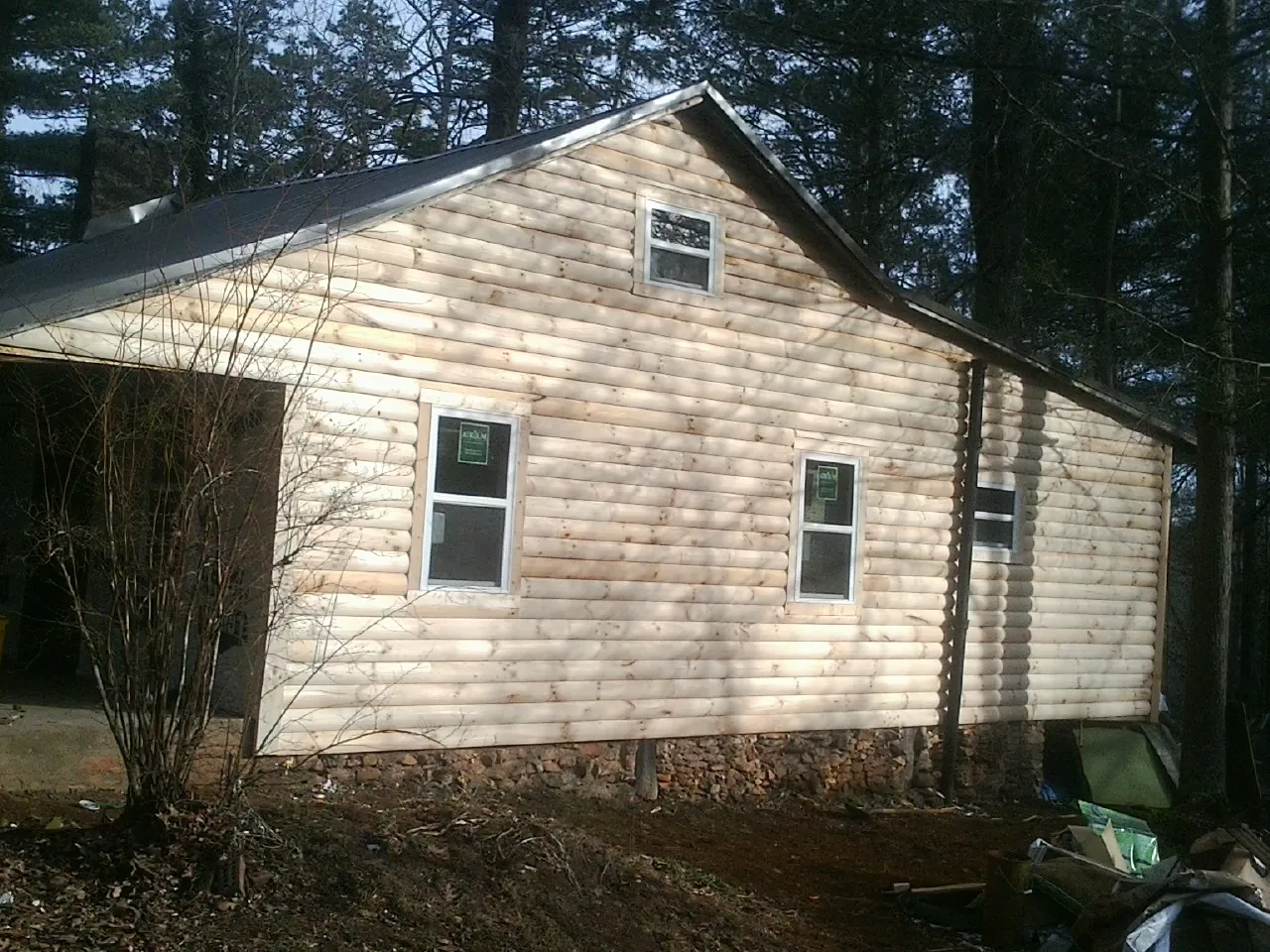 New log siding and dark metal roofing on a gable end in New Florence
