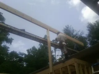 Carpenter setting a ridge beam over a new addition frame — Ice Dam Removal by Roofing Brothers in New Florence