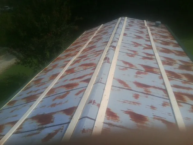 Rusted metal roof panels with new wood purlins before replacement — Storm Damage Roof Repair in New Florence by Roofing Brothers