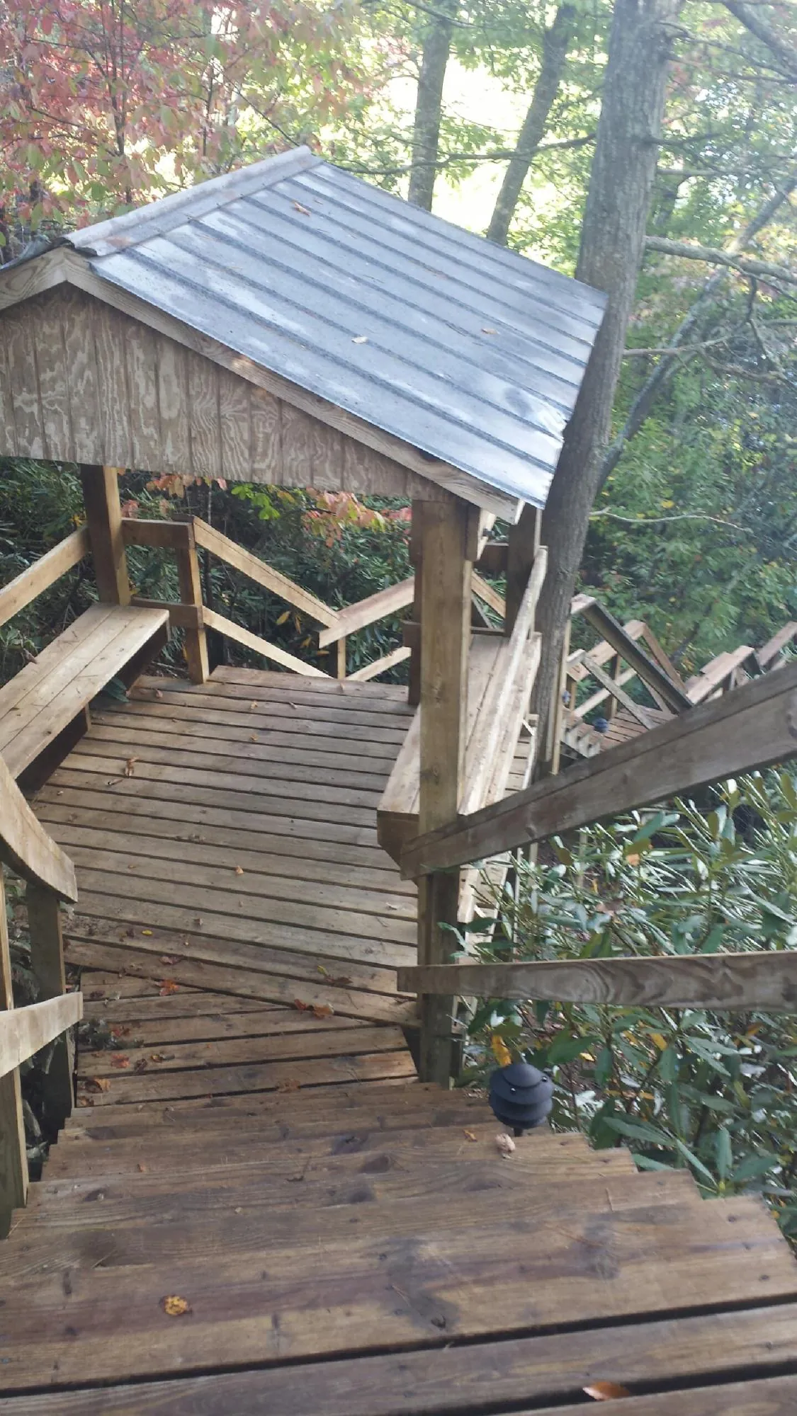 Metal roofed shelter over wooden steps on a wooded walkway — Skylight Repair & Installation work by our crew in New Florence