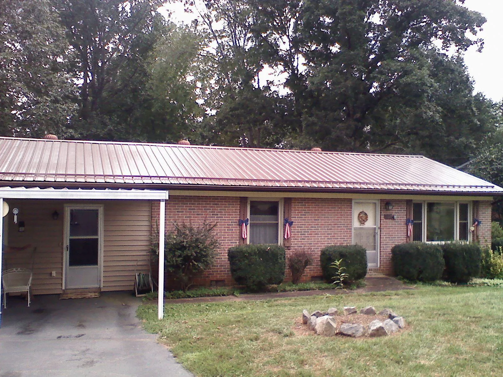 Bronze metal roof and carport on a brick ranch home — Roof Repair work by our crew in New Florence