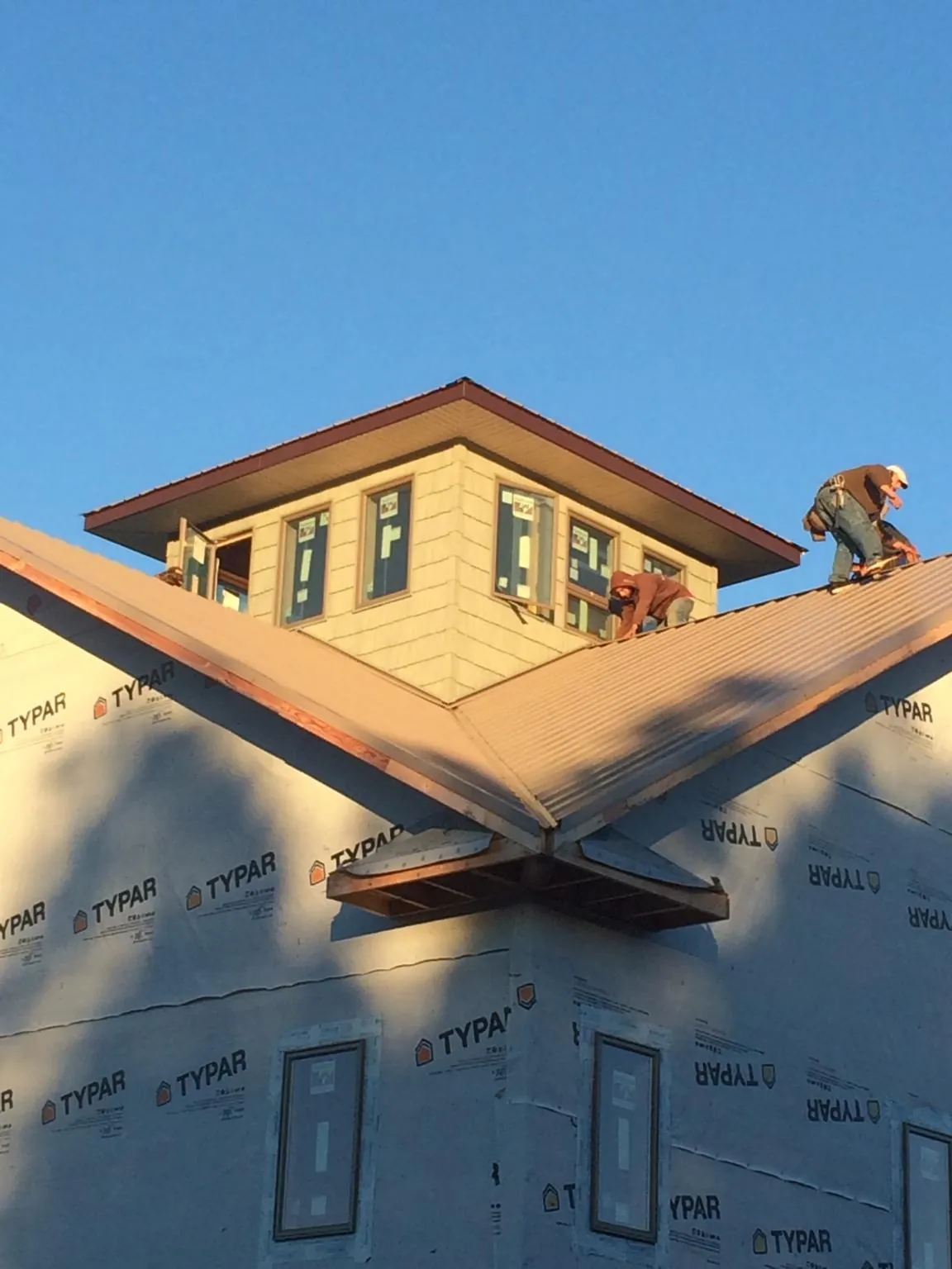 Roofers working around a rooftop cupola on a new metal roof at sunset — Roof Waterproofing in New Florence by Roofing Brothers